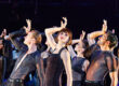 Kailin Brown as Velma in the musical Chicago. There are other people around them and they are in a pose from the number "All That Jazz" with their hand on their forehead. They are leaning towards the right side,