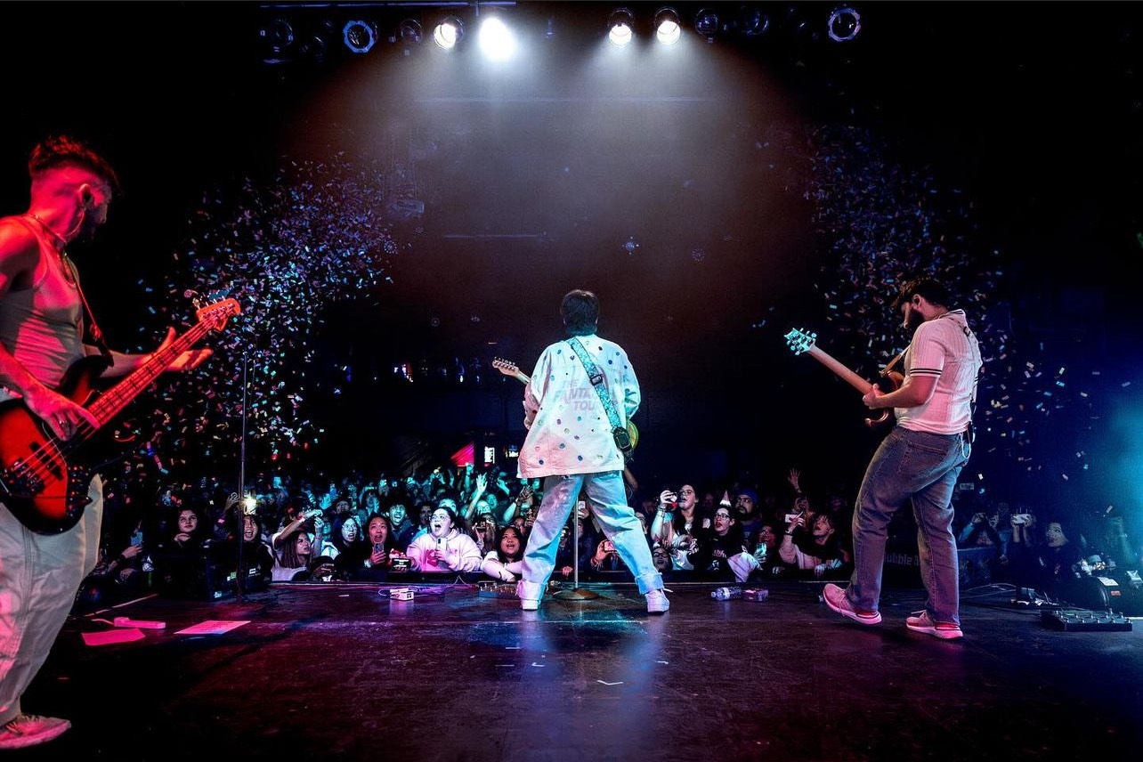 three guys performing on stage in front of a crowd