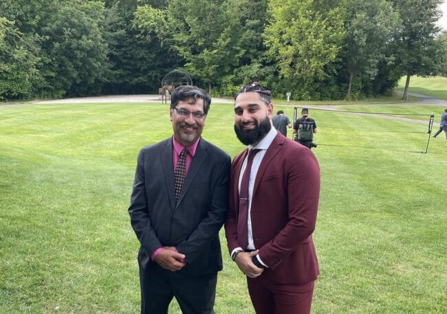 IMG_0969 Father and son standing next to each other in a field.