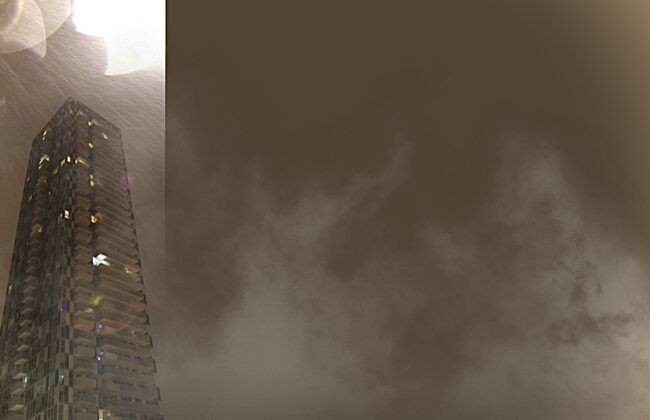 A 40 storey condominium stands out in a dark, rainy sky, bright white sparks near its roof