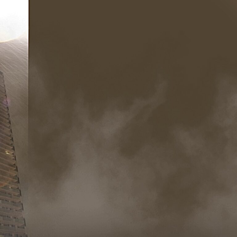 A 40 storey condominium stands out in a dark, rainy sky, bright white sparks near its roof