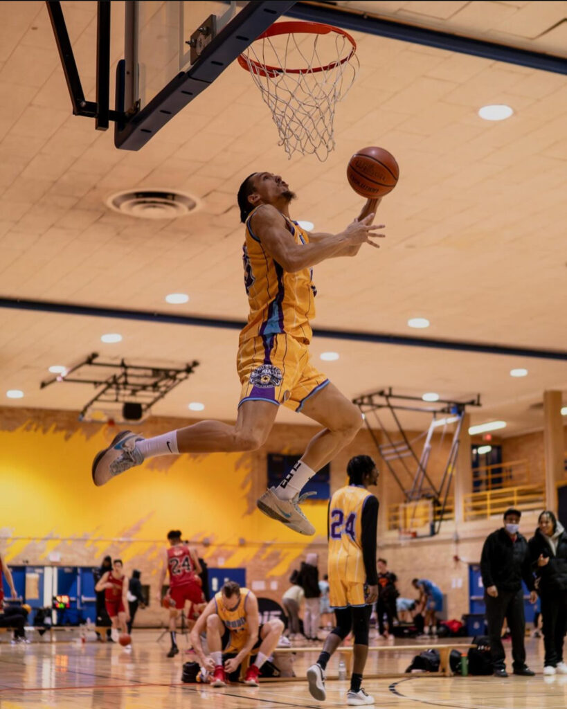 Man in yellow jersey performs a dunk