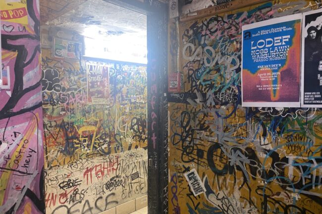 Walls of Sneaky Dee's bar. Spray paint and graffiti covers head to toe.