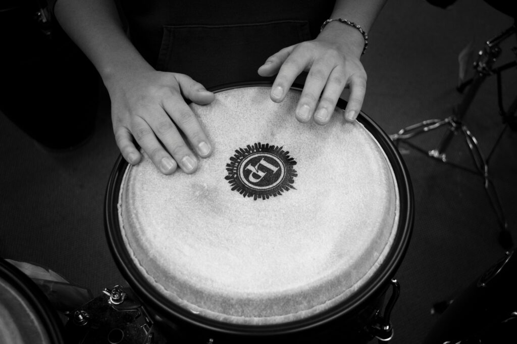 A black and white image of a person playing drums.