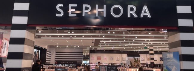 sephora entrance The entrance to a store that says "Sephora" in white capital letters at the top of the entrance, with a glimpse of the store at the bottom.