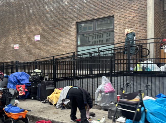 belongings sprawled across a homeless encampment